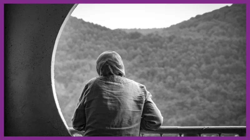 A Person sits quietly by a window, reflecting on there recovery after trauma.